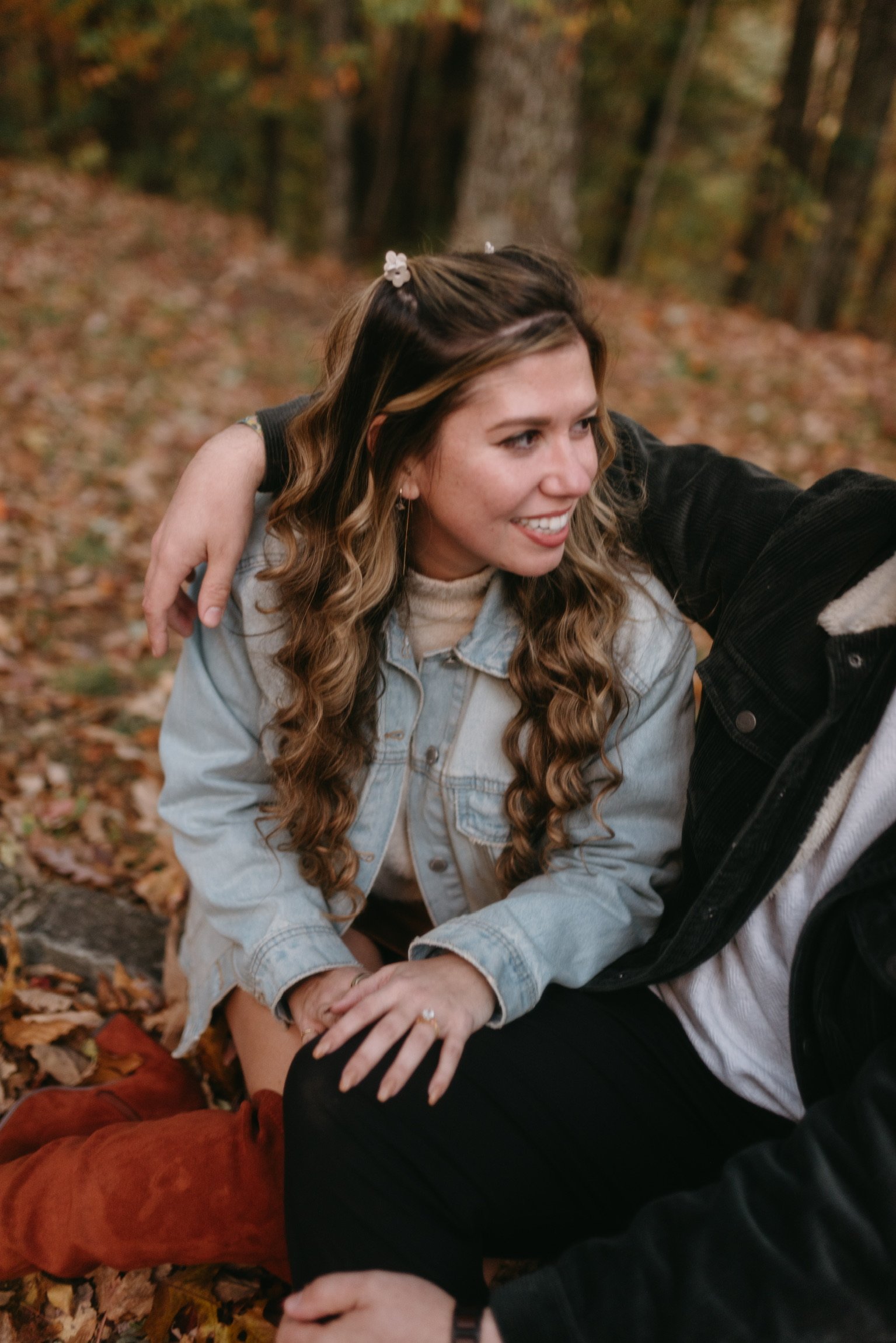 Nicole smiling off to one side, Ian’s arm around her shoulders as they sit in the leaves.