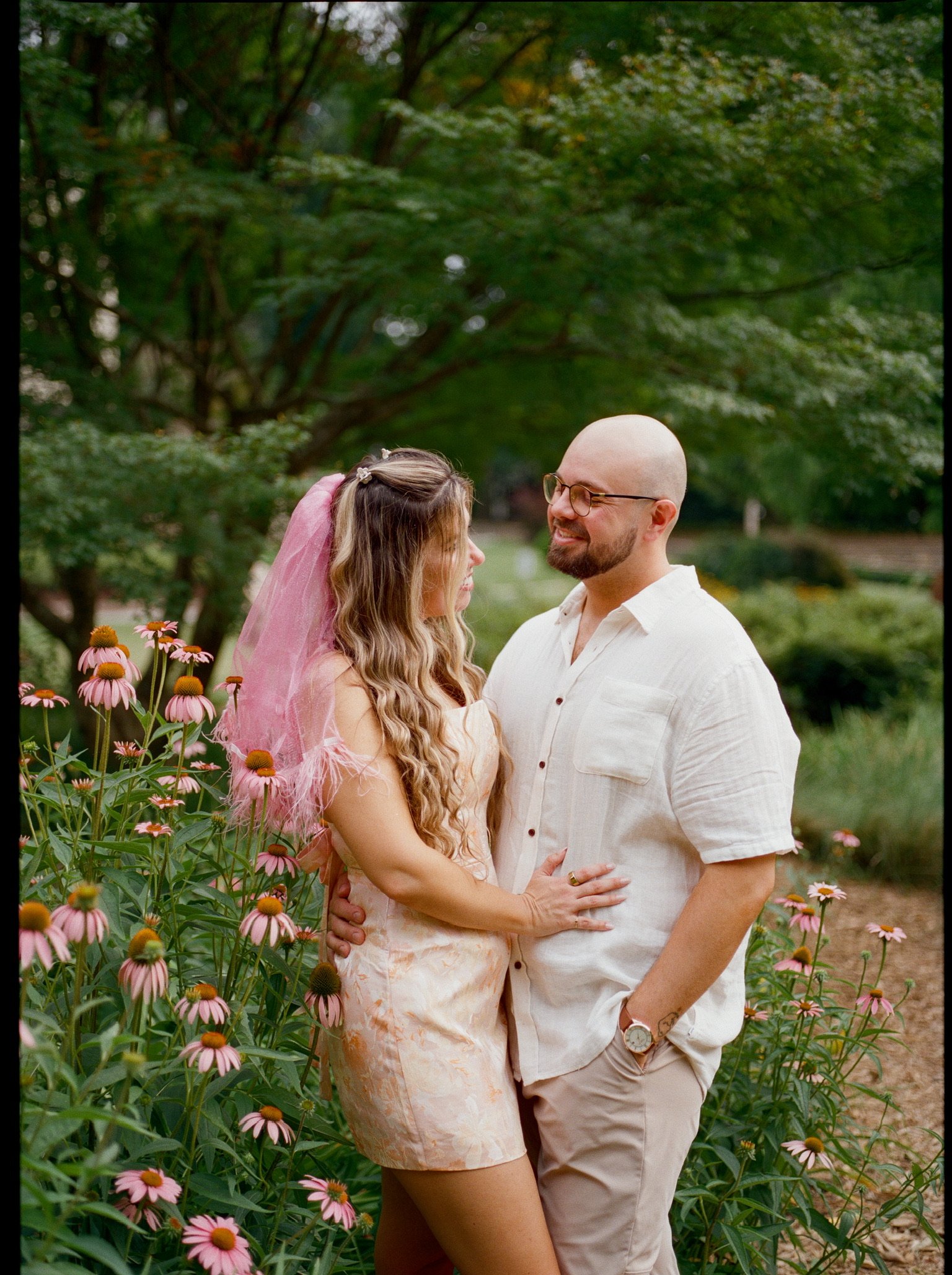 Nicole and Ian smiling at each other among the coneflowers.