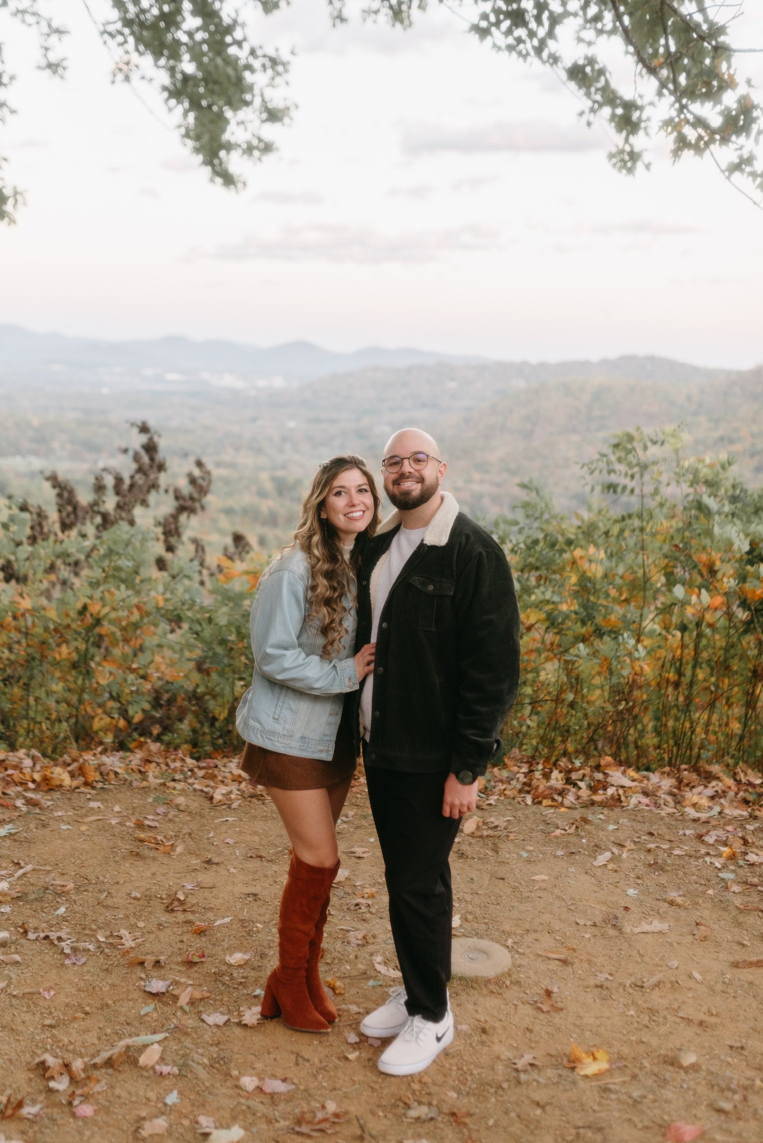 Nicole and Ian standing together at the overlook, smiling at the camera.