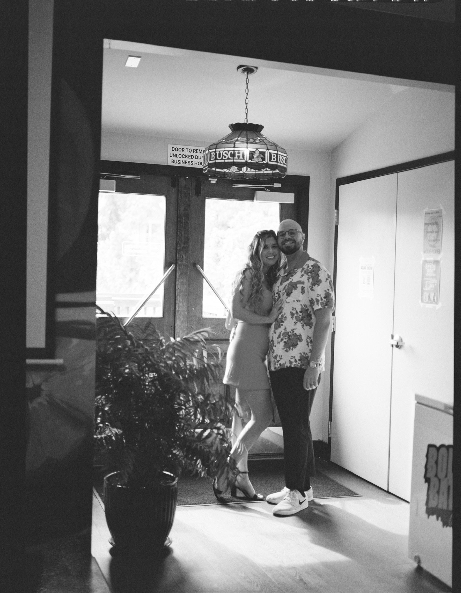 In black and white: the two of them in the entrance hall beneath the stained-glass lamp.