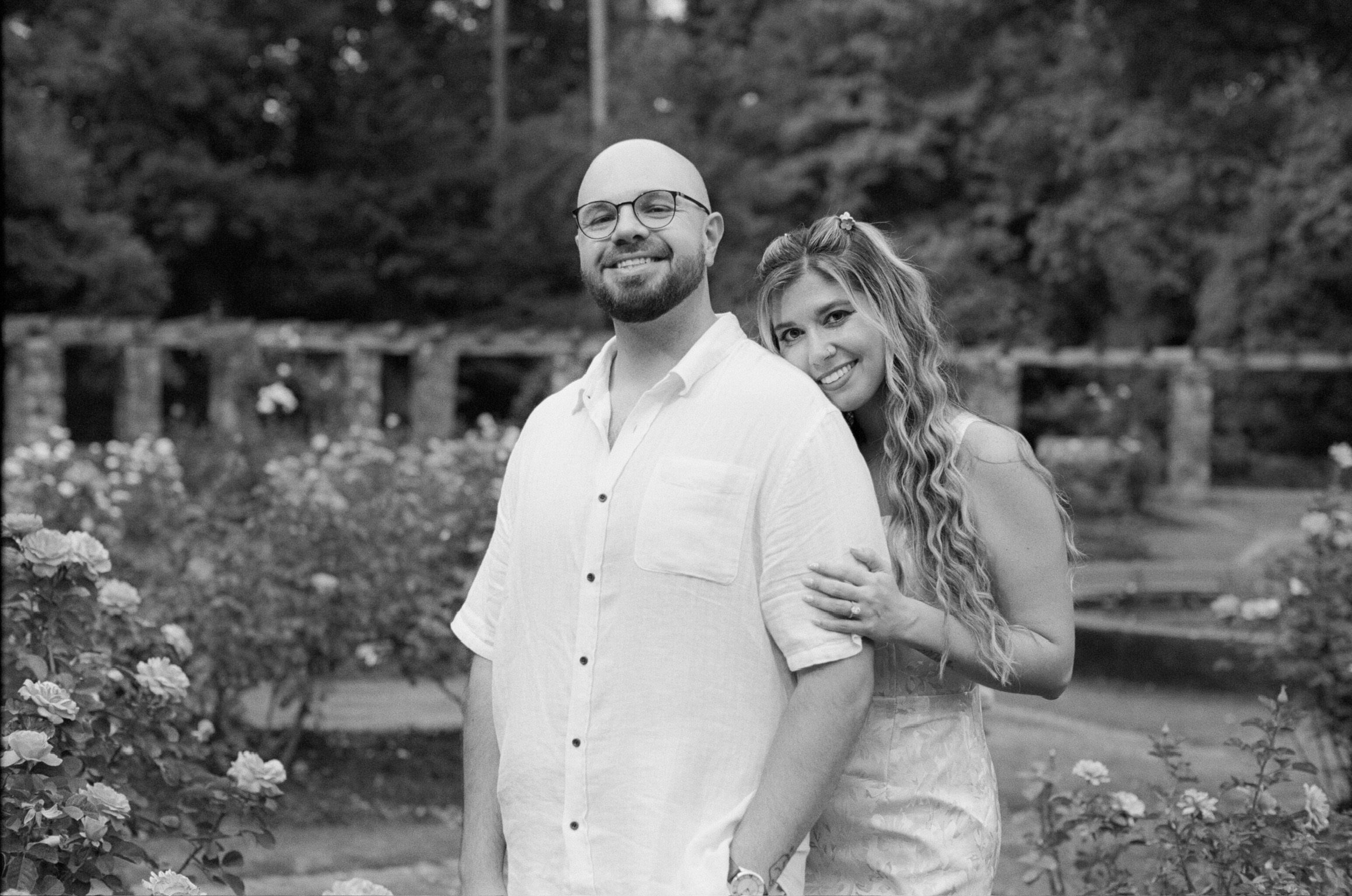 In black and white: Ian and Nicole standing together in the rose garden, her head on his shoulder.
