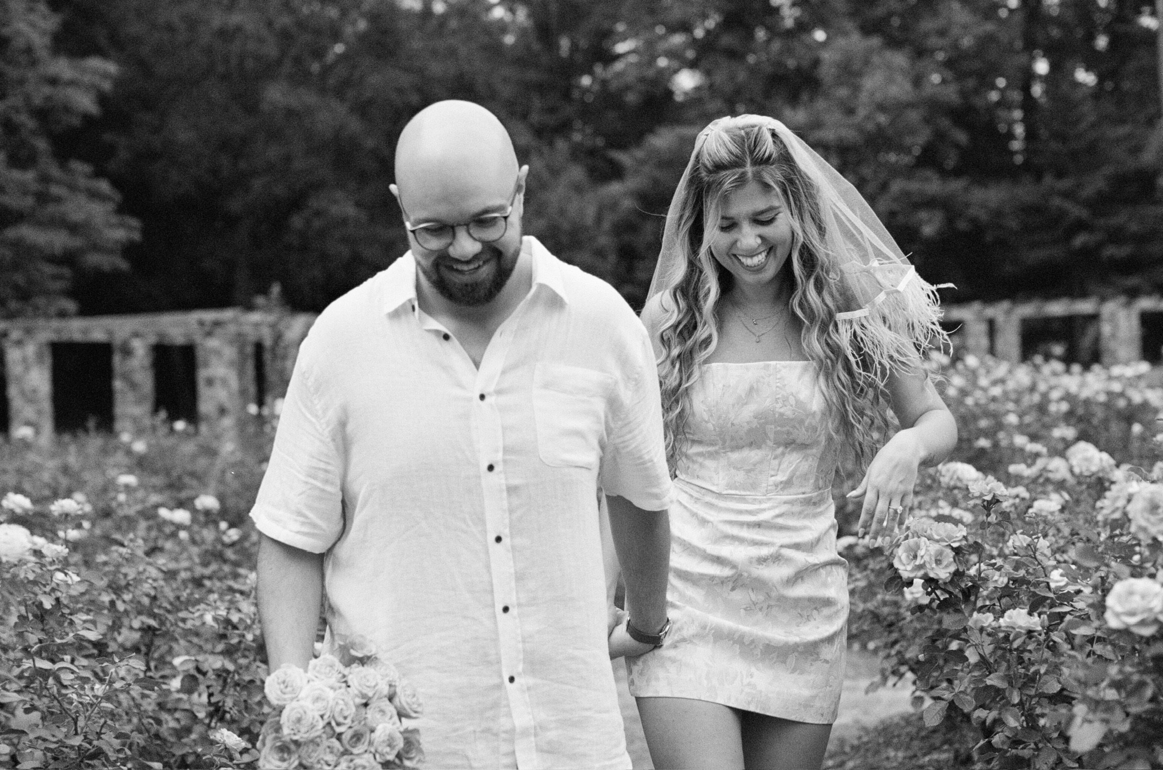 In black and white: Nicole in her veil laughing as she and Ian walk through the roses.